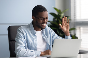 Happy african american worker greeting partners or clients. © fizkes