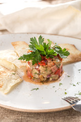 Grilled vegetables warm salad with zucchini, eggplant, onions, peppers and tomato and lavash bread on grey tablecloth