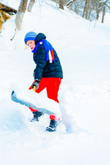 The boy shovels the snow near his house in winter. 2019