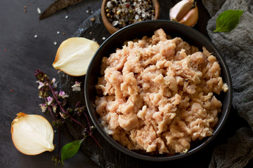 Minced meat and ingredients for cooking minced meat in a bowl on a slate.