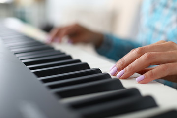 Close-up of female hands playing synthesizer in music workshop. Professional cute pianist creating new musical composition. Art concept. Blurred background