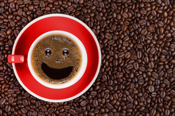 coffee background of hot black coffee with smile bubble in red cup on roasted arabica coffee beans background