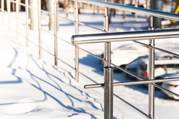 Metal handrail on winter stairs. Dangerous stairs under snow, safe handrail.