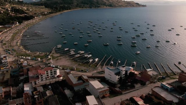 Copacabana, Bolivia - August 2019: Panoramic aerial DRONE Lake Titicaca view. Cityscape with water, hills, buildings, town. Bolivian tourism. Lakeside city of town. Harbor with boats. Travel. 2019