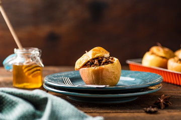 Obraz na płótnie Canvas Baked apples stuffed with muesli, raisins and nuts. Spiced with honey and cinnamon