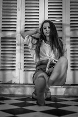 Lifestyle of a young smiling brunette sitting, black and white photo