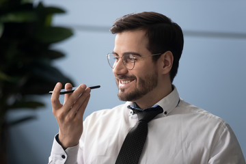 Happy millennial businessman using virtual assistant service.