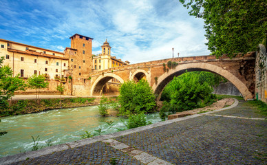 Fototapeta premium Tiber Island and Fabricius Bridge on the river Tiber in Rome, Italy. Exterior, architecture and landmark of ancient streets in Rome.