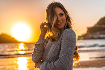 Obraz premium Seksowny look w sesji Lifestyle blondynki w szarej sukience na zachodzie słońca
