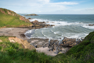 Stunning late evening Spring landscape image of Ayrmer Cove on Devon coastline in England