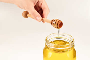 Dipper with honey in woman hand. Space for text or design.