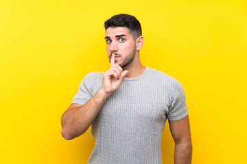 Young handsome man over isolated yellow background doing silence gesture