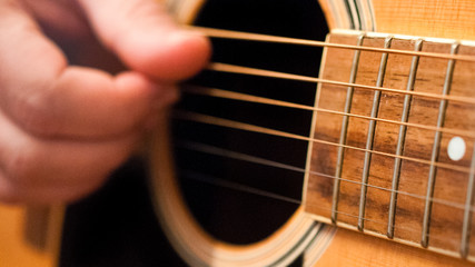 Detail of man playing an acoustic guitar. 16:9 image