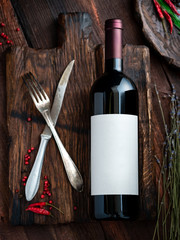 Red wine bottle Mock-Up on wooden table. Blank label for designers, top view, rustic style
