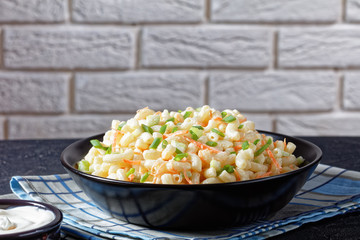 creamy macaroni salad in a black bowl