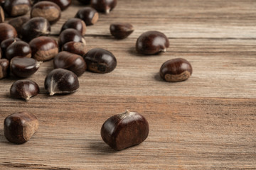 ripe and fresh chestnuts on wooden table with copy space