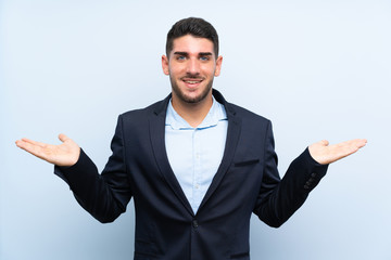Handsome man over isolated blue background with shocked facial expression