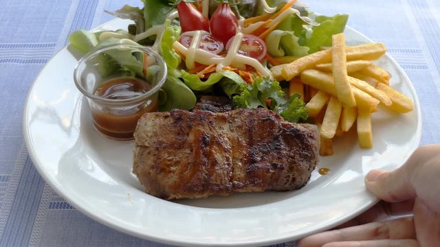 Grilled steak with french fries and fresh vegetables on white plate