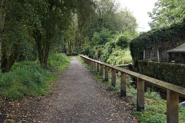Path with trees to one side and wooden fence to the other in Huddersfield Yorkshire England