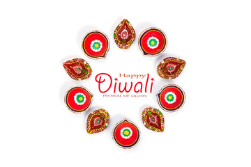 Happy Diwali - Clay Diya lamps lit during Dipavali, Hindu festival of lights celebration. Colorful traditional oil lamp diya on white background. Copy space for text.