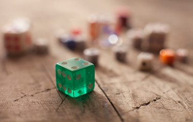 Green dice on wooden background. All number five. Concept of luck, chance and leisure fun.