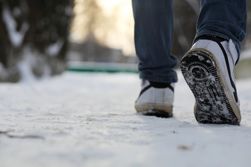 A man walks through the city on snowy winter day.