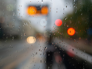 Rainy autumn day waiting bus stop behind the windows urban view