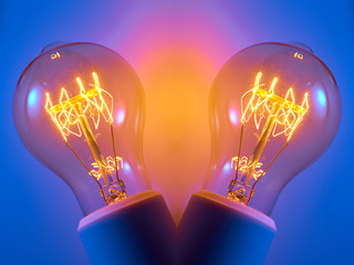 Alte Glühlampe mit orange leuchtendem Glühwendel.