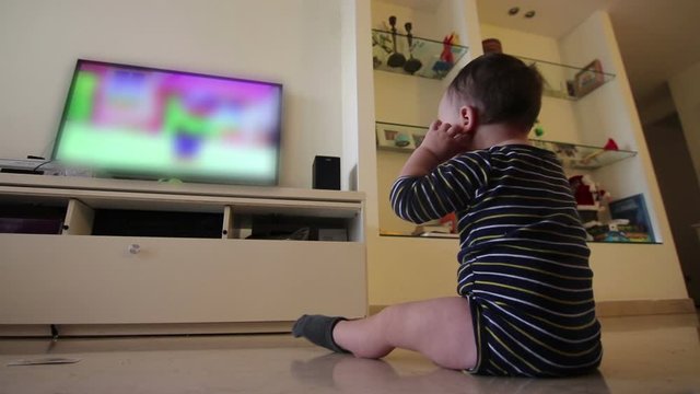 baby watching blurred content on TV