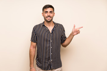 Handsome man with beard over isolated background pointing finger to the side