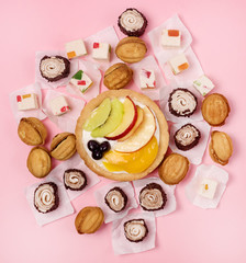 Tasty Homemade Mini Tart with Italian Meringue decorated with fruits and Berry and Lokum on Pink Background Copy Space Tasty Dessert