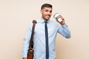 Naklejka premium Young business with beard holding a take away coffee