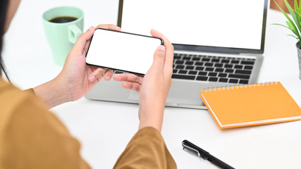 Close-up young woman holding smartphone with isolated screen.