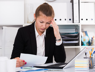 Office worker woman in black suit is having complicated issue with project