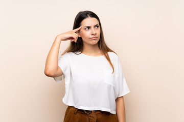 Young brunette woman over isolated background making the gesture of madness putting finger on the...