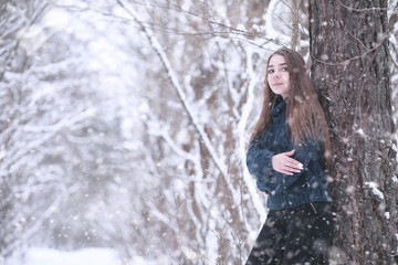 Girl in a winter park in snowfall