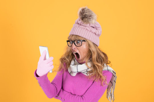 warm woman with winter clothes talking on the phone isolated on color background