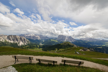 Tre panchine in fila in un punto panoramico sulle Dolomiti con vista sul Gruppo Sella e Sassolungo