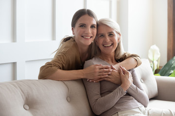 Loving daughter hug mother people posing looking at camera