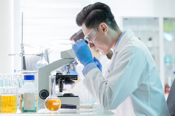 Asian scientist use microscope