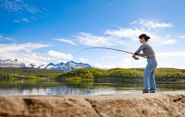 Woman fishing on Fishing rod spinning in Norway.