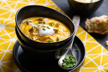 Pumpkin soup with sour cream, herbs and pumpkin seeds.