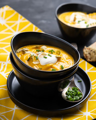 Pumpkin soup with sour cream, herbs and pumpkin seeds.