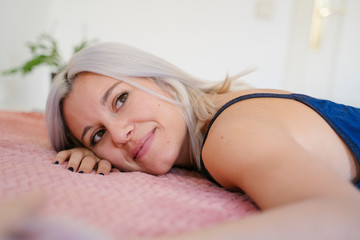 Fototapeta premium The importance of a good night sleep. Calm and relax dreams. Beauty and healthy lifestyle. Single woman resting on a pillow at home. Lifestyle at home. Young people. White clean mindfulness room.