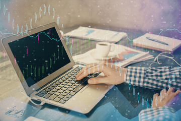 Double exposure of forex chart with man working on computer on background. Concept of market...