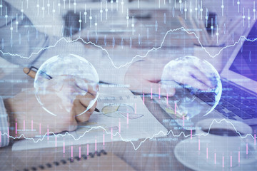 Multi exposure of stock market graph with man working on laptop on background. Concept of financial analysis.