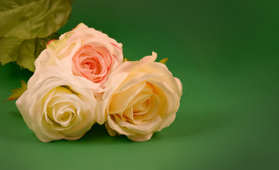 Fototapeta premium Three white roses stock images. White roses on a green background. White flowers decoration. Artificial flowers stock images