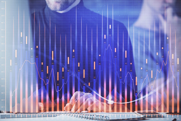 Forex graph with businessman typing on computer in office on background. Concept of analysis. Double exposure.