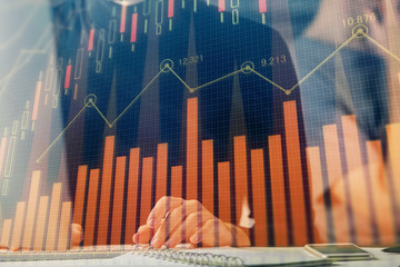 Obraz premium Forex graph with businessman typing on computer in office on background. Concept of analysis. Double exposure.