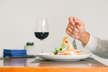 Close up of man eating salad chicken with fork. Hand holding fried chicken with a plate of salad chicken with vegetables - Image